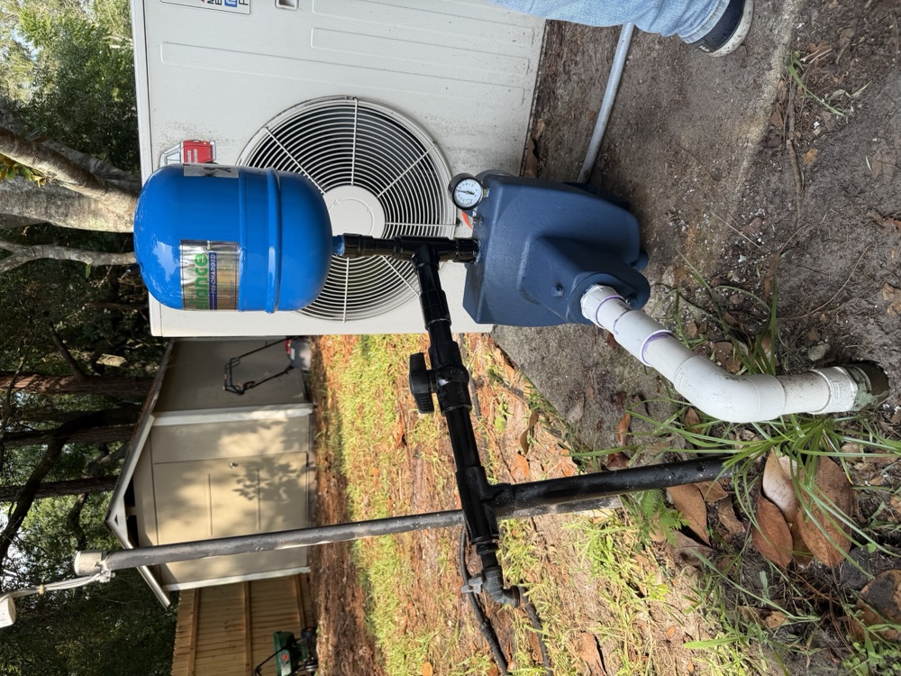 Well pump and pressure tank installed beside a house in Clay County